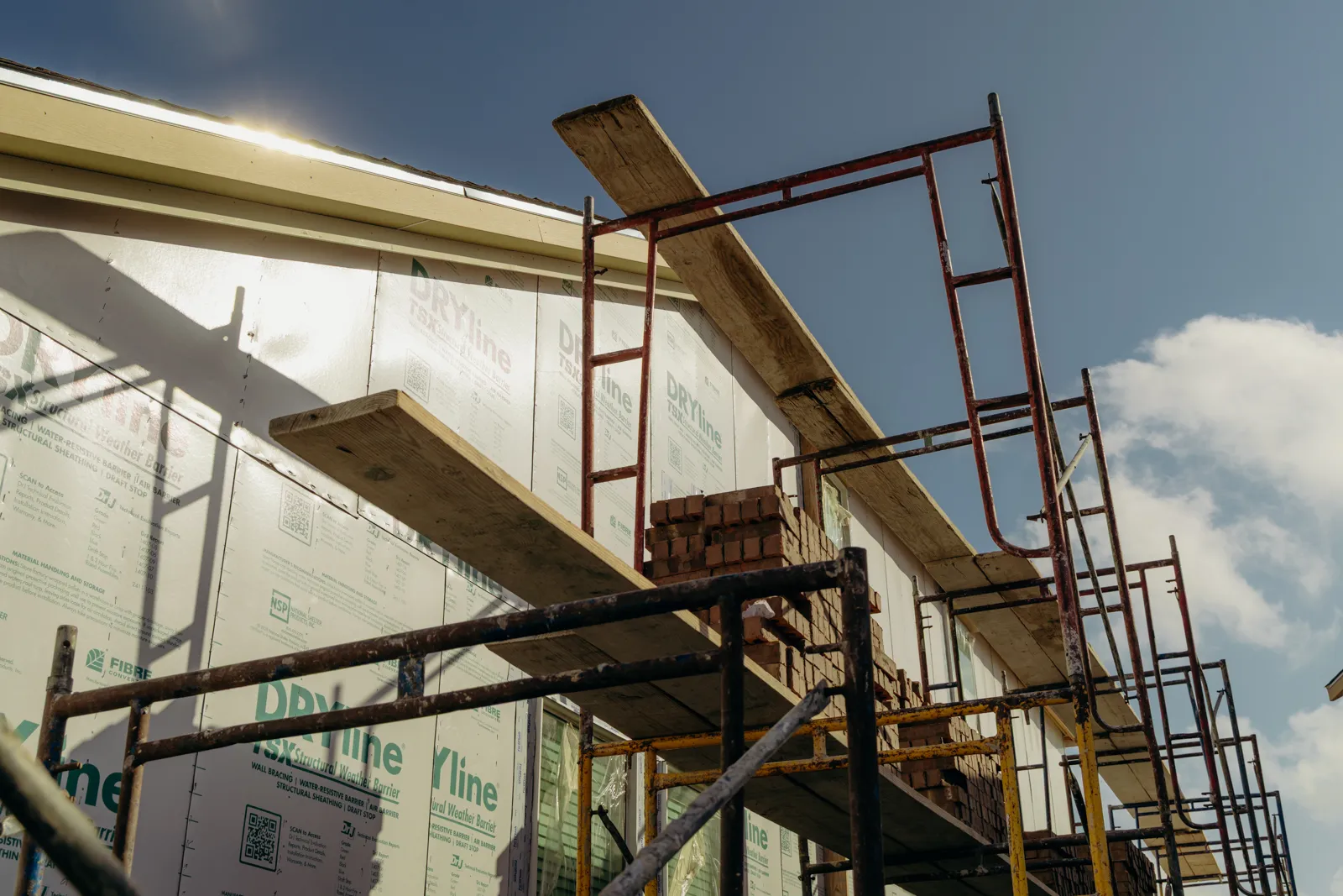Scaffolding against a sheathed house